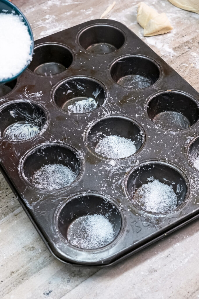 Preparing buttered muffin tin