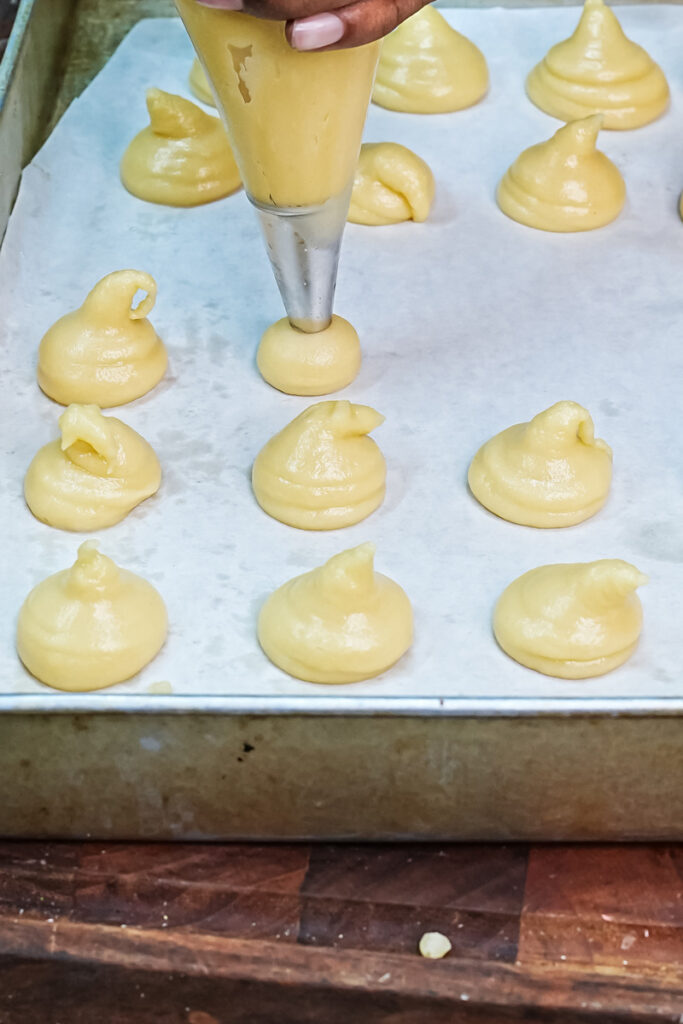 Raw choux pastry piped on baking sheet before baking