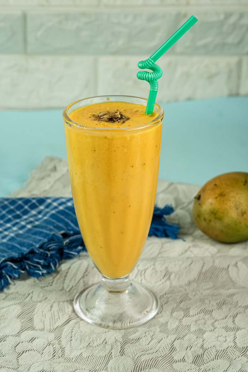 Refreshing mango lassi with curly straw garnish