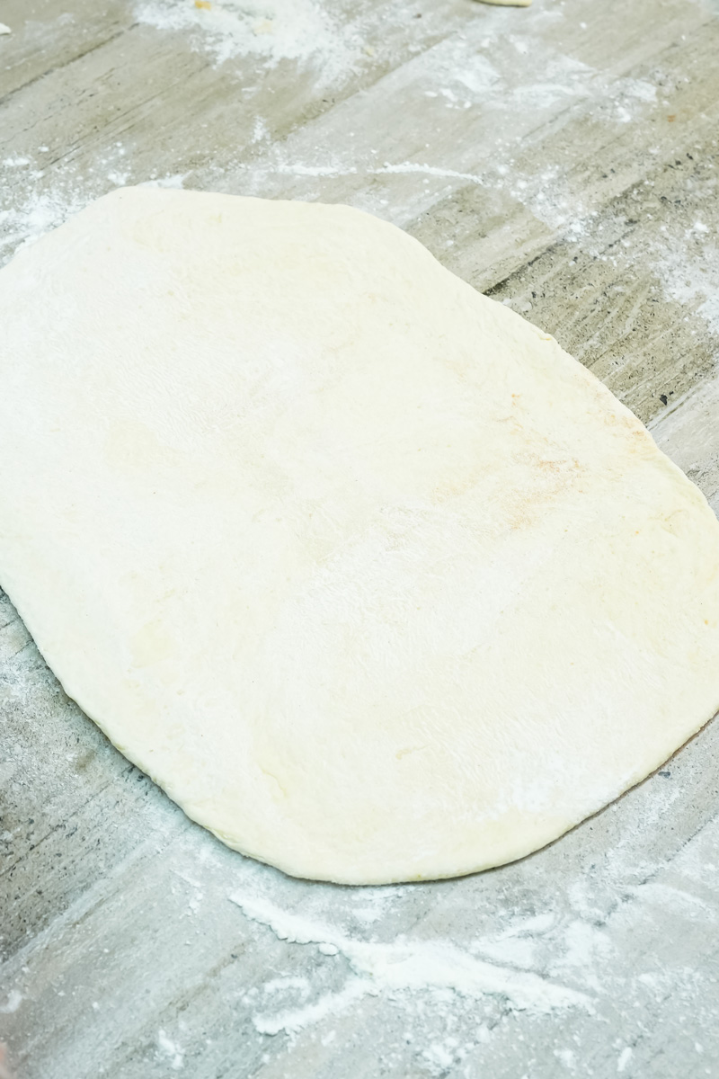 Rolled pastry dough on floured marble surface