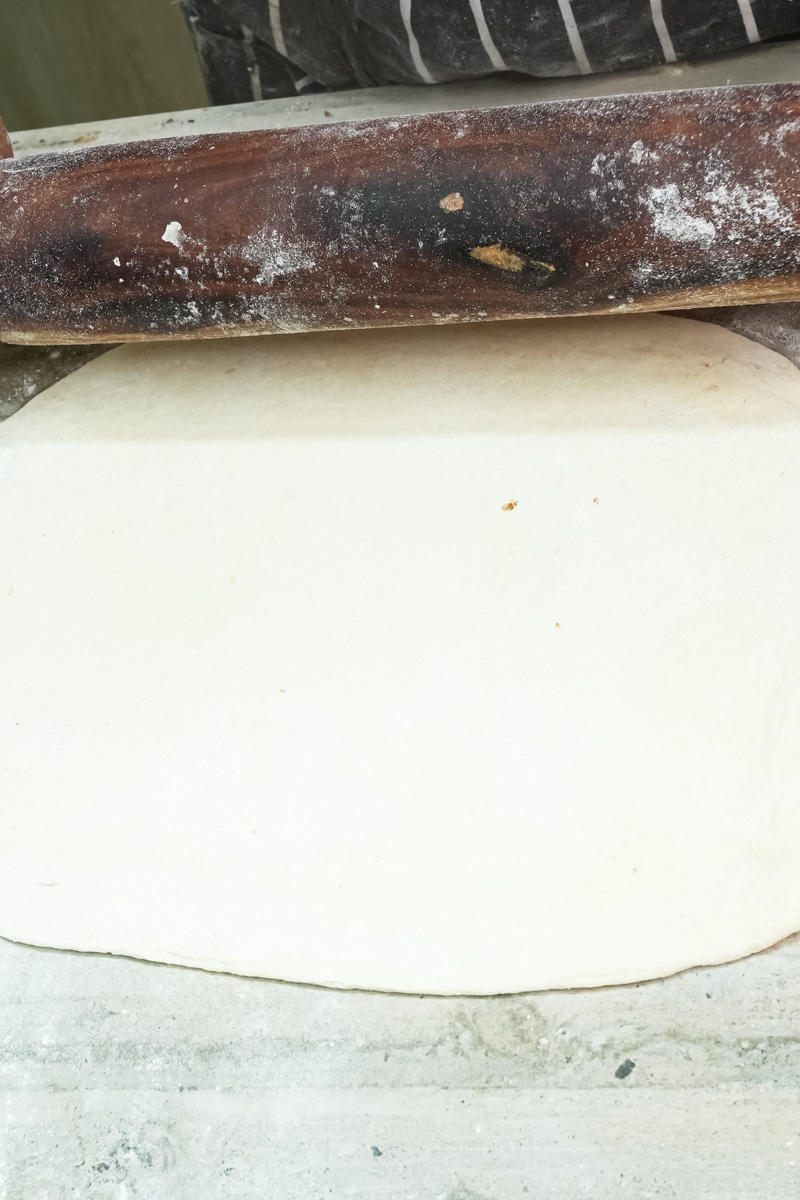 Rolling out laminated croissant dough with rolling pin