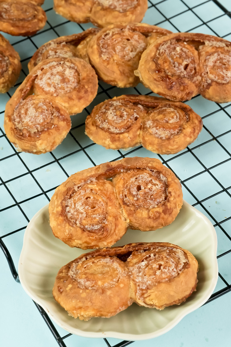 Served palmiers on white plate with cooling rack