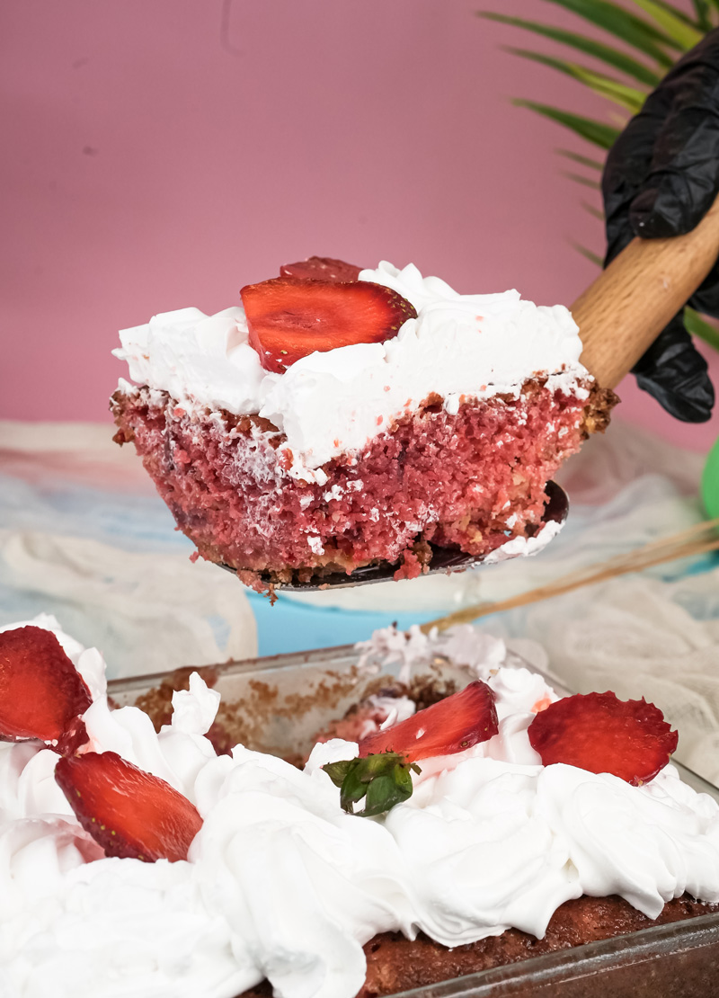 Serving slice of strawberry earthquake cake showing layers