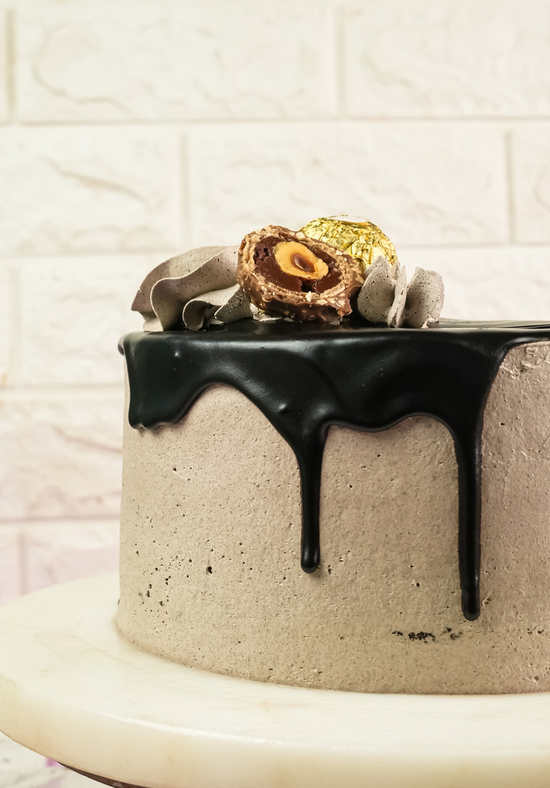 Side view of Ferrero Rocher cake showing chocolate drip glaze