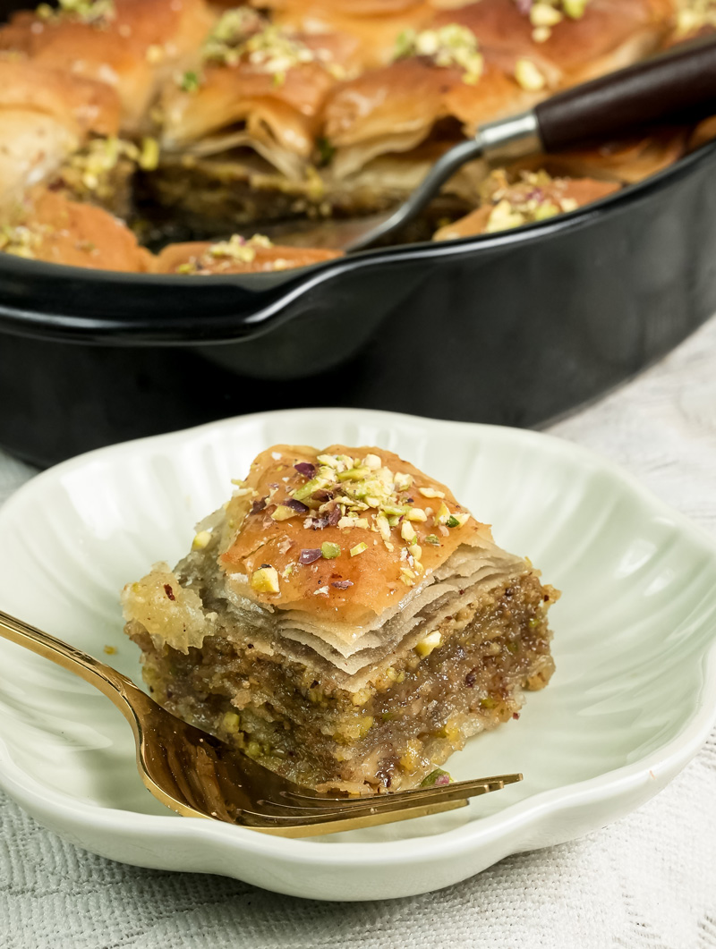 Single baklava piece plated with fork showing layers