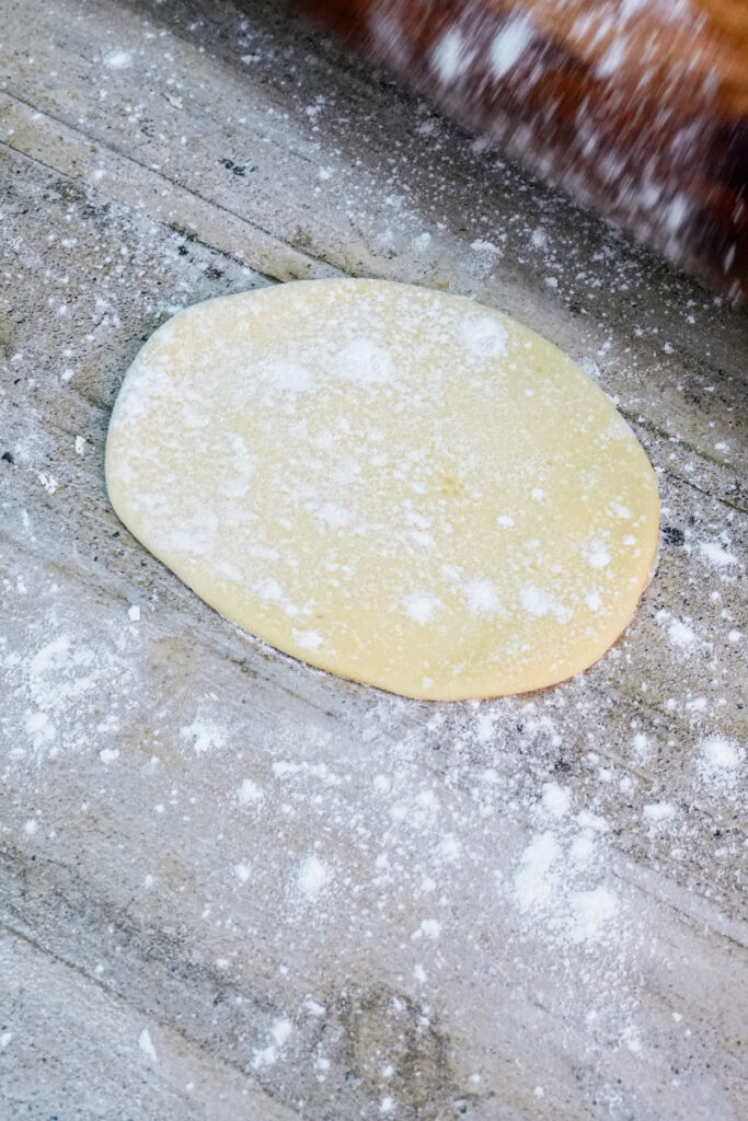Single empanada dough circle dusted with flour