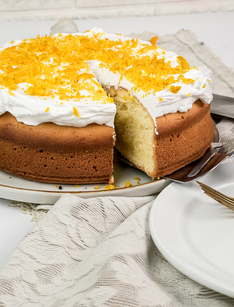 Sliced citrus cake showing light fluffy texture and white frosting