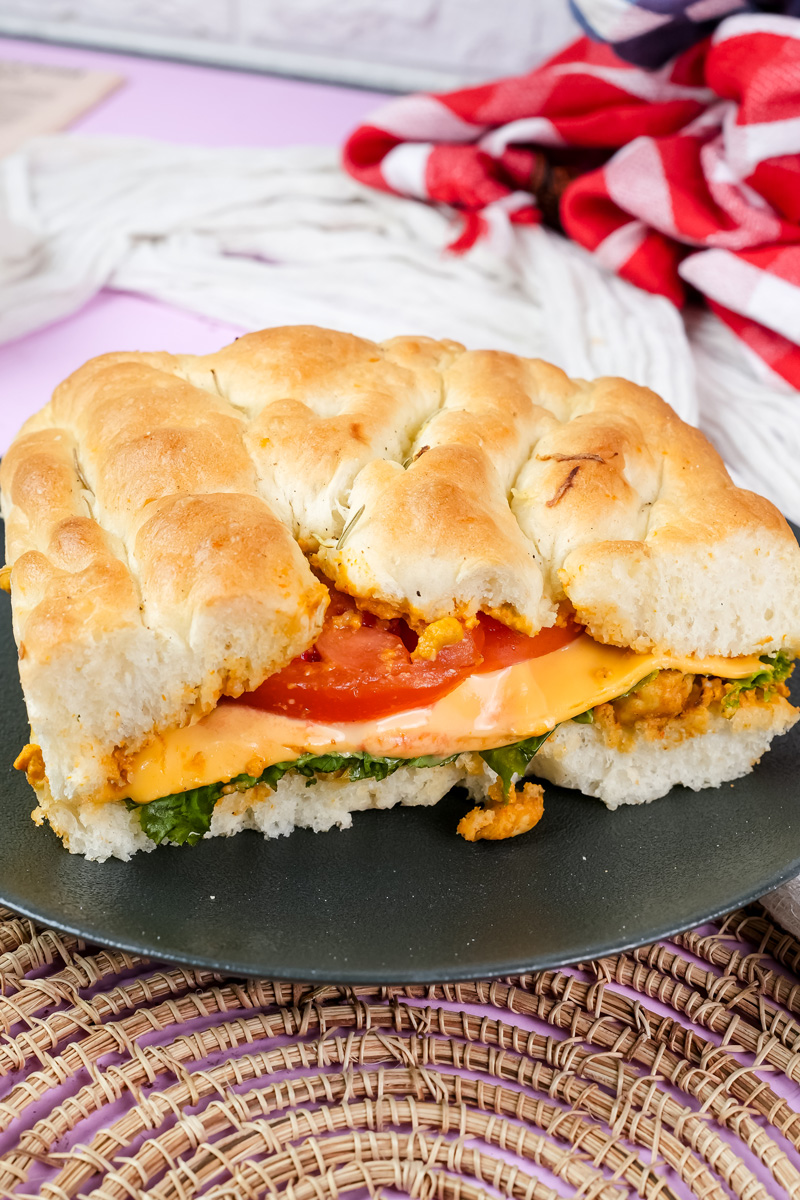 Sliced focaccia sandwich with tomato, cheese and greens filling