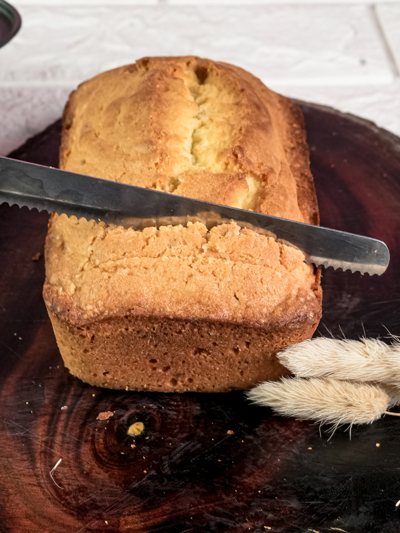 Slicing homemade Madeira cake with serrated knife