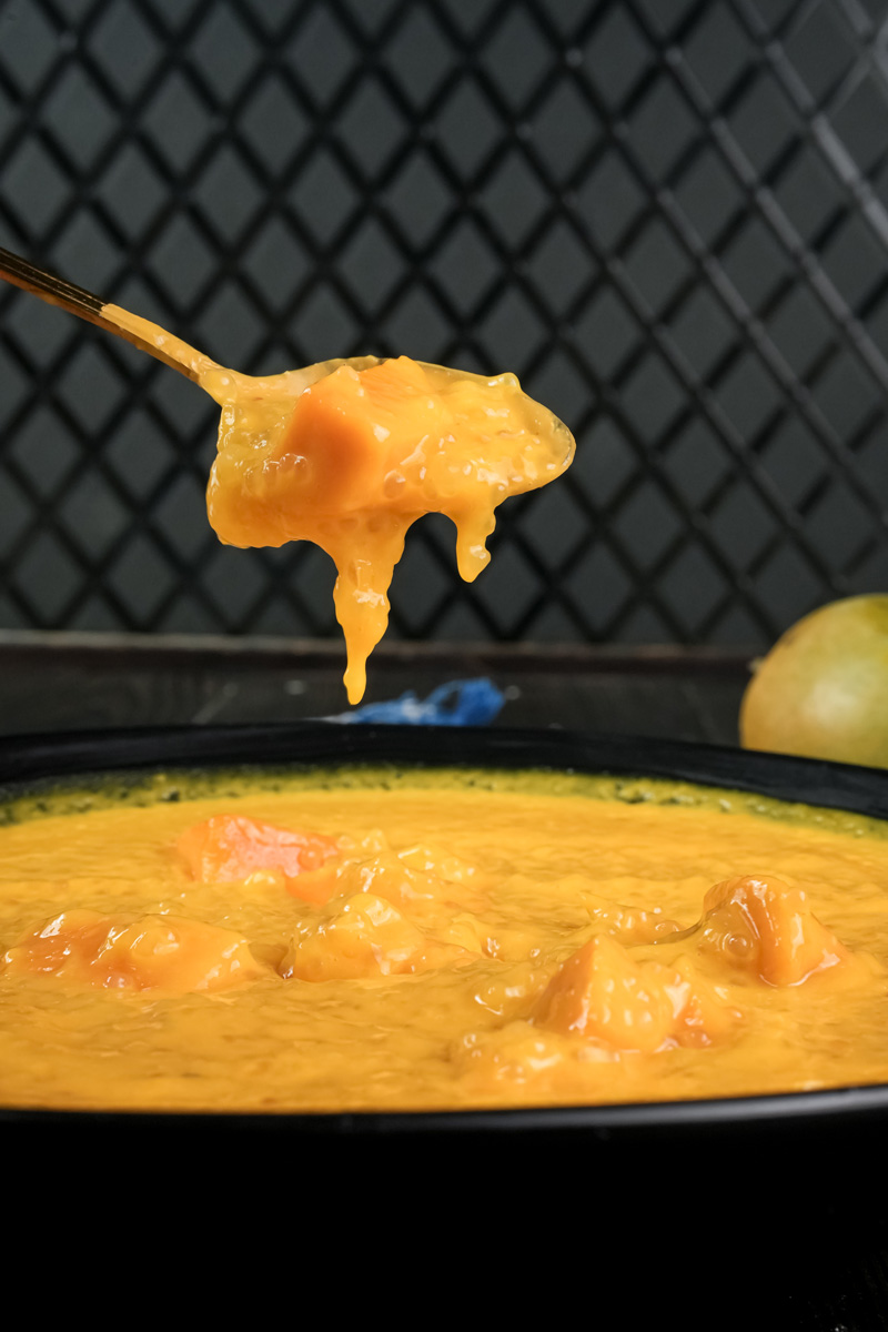 Spoonful of creamy mango sago showing smooth texture