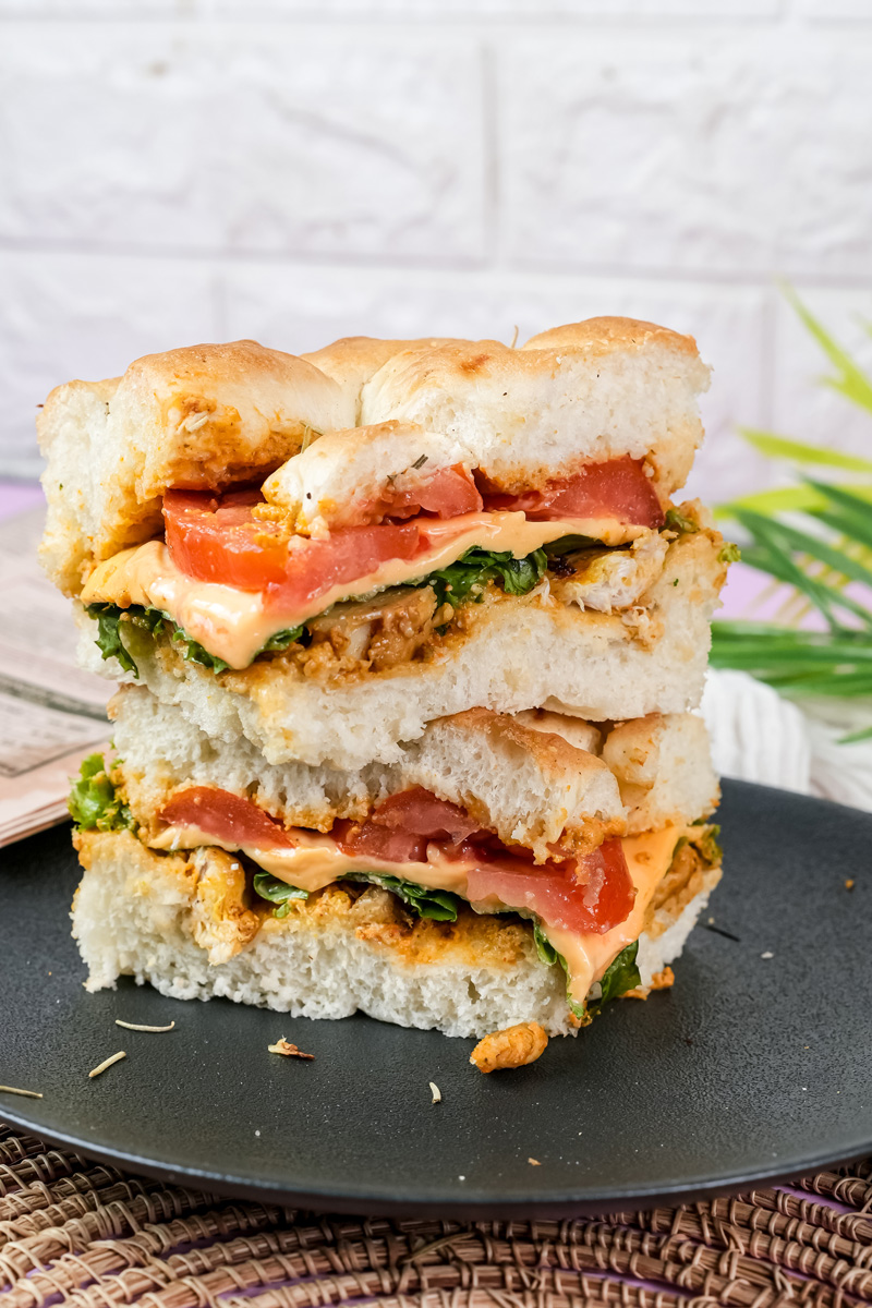 Stacked focaccia sandwich halves showing thick bread and fillings