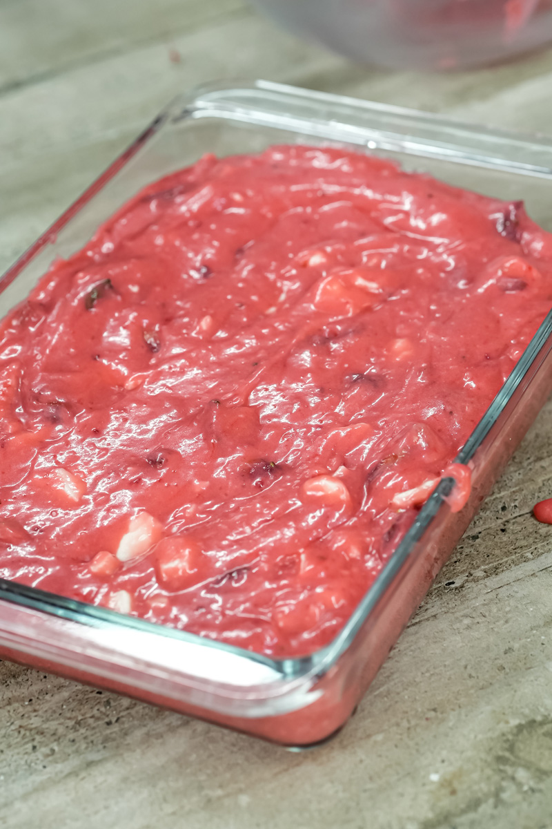 Strawberry earthquake cake batter spread in glass baking pan