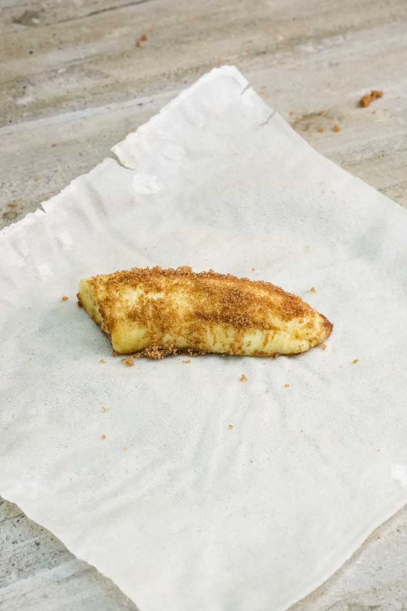 Sugar-coated banana piece on parchment paper