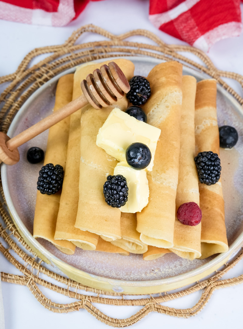 Thin pancake rolls topped with fresh blackberries and blueberries