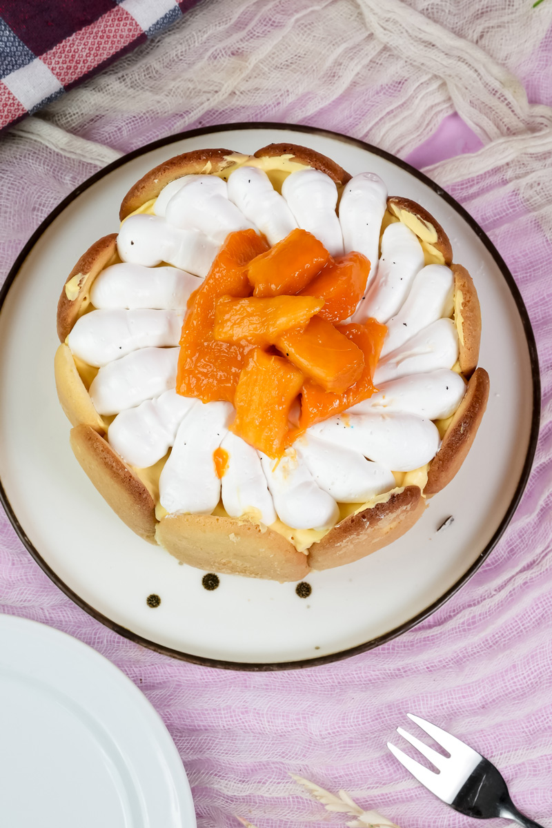 Top view mango charlotte cake with white cream border and mango center