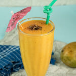 Tropical mango lassi with cocktail umbrella and straw