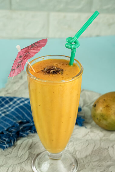 Tropical mango lassi with cocktail umbrella and straw