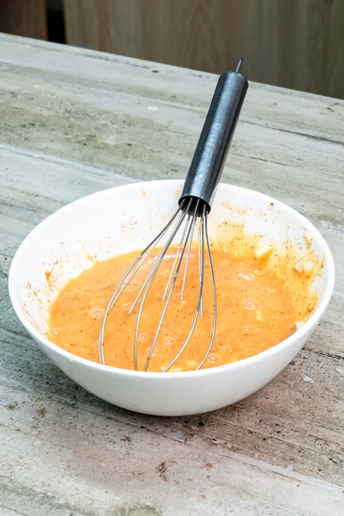 Whisking paprika egg wash for Korean bun topping