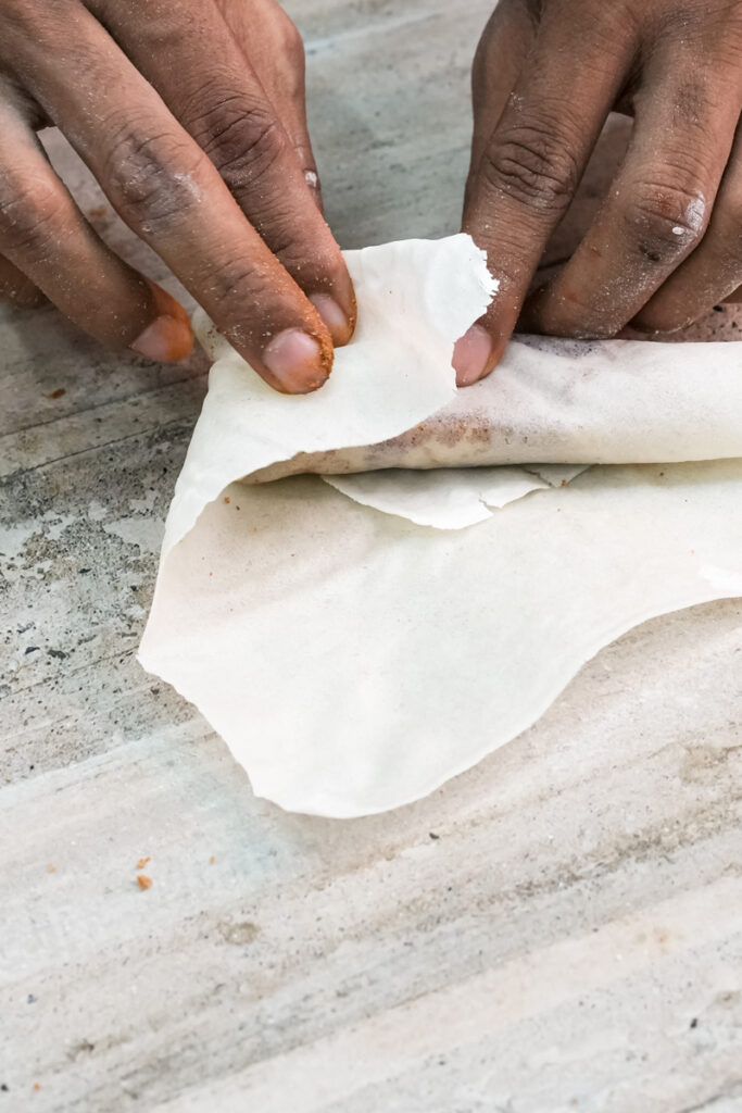 Wrapping banana in lumpia wrapper by hand