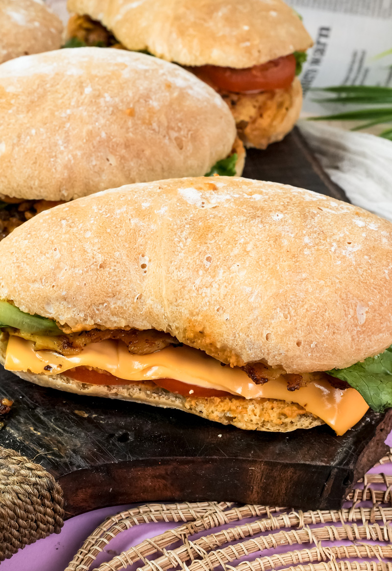 Close-up ciabatta sandwich with melted cheese and vegetables