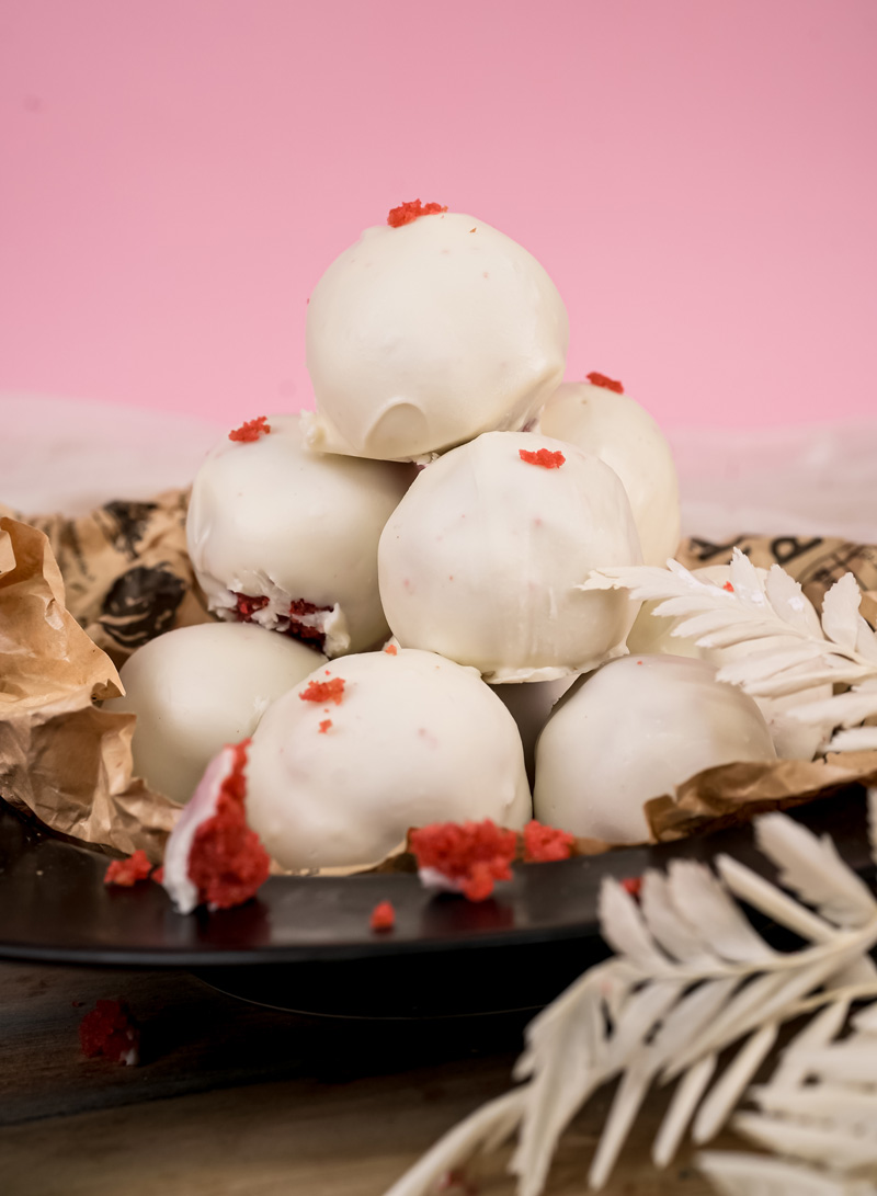 Close-up of decorated strawberry cake pops with red crumb garnish