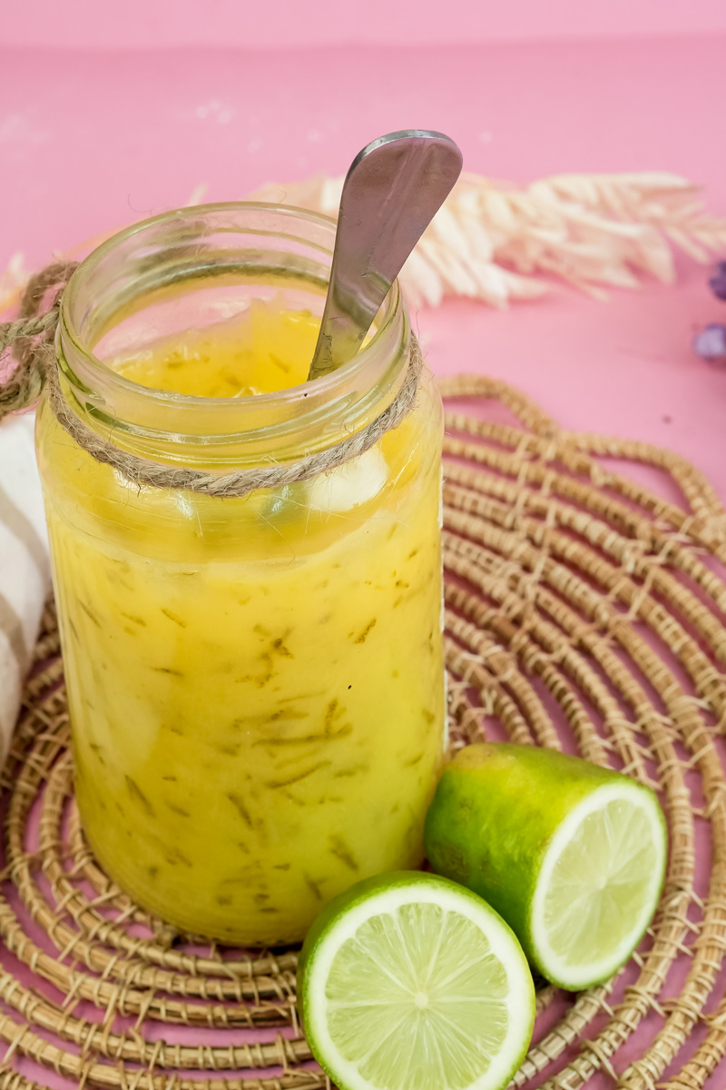 Close-up of lemon curd texture in glass jar with lime garnish