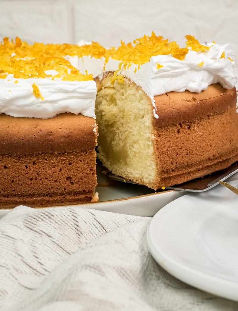 Cross-section view of moist citrus cake with cream cheese frosting