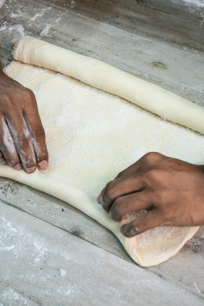 Continuing to roll palmiers dough into tight cylinder