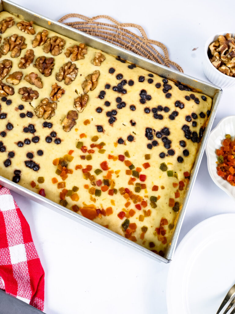 Unbaked sheet pan pancakes with colorful toppings arranged in sections