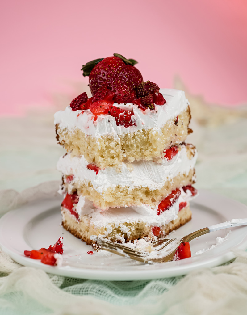 Partially eaten strawberry shortcake slice showing fluffy cake texture