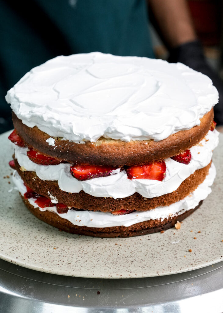 Finished three-layer strawberry shortcake with thick whipped cream frosting