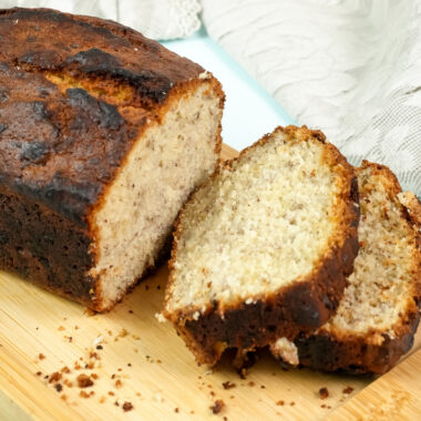 A loaf of banana bread with two thick slices cut from it.