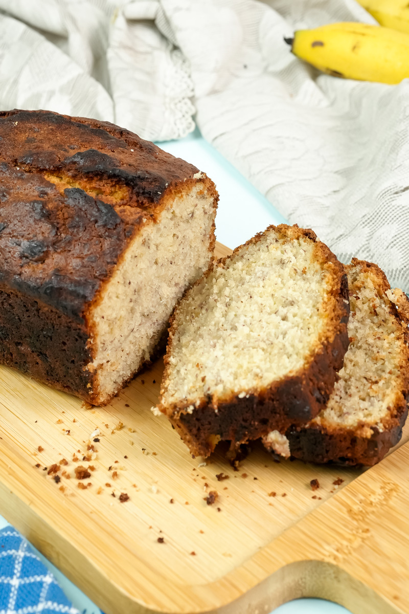 A loaf of banana bread with two thick slices cut from it.