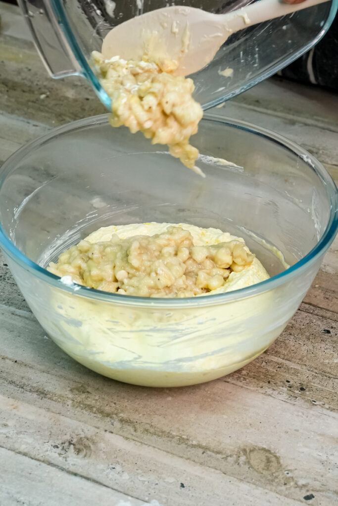 Adding freshly mashed bananas to the wet ingredients for Hawaiian banana