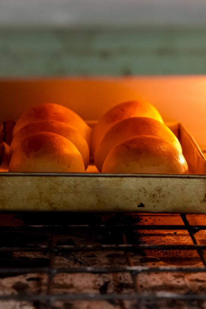 Bread bowls baking in the oven, turning a golden brown color.