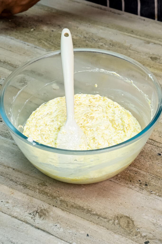 Folding mashed bananas into the creamy banana bread batter.