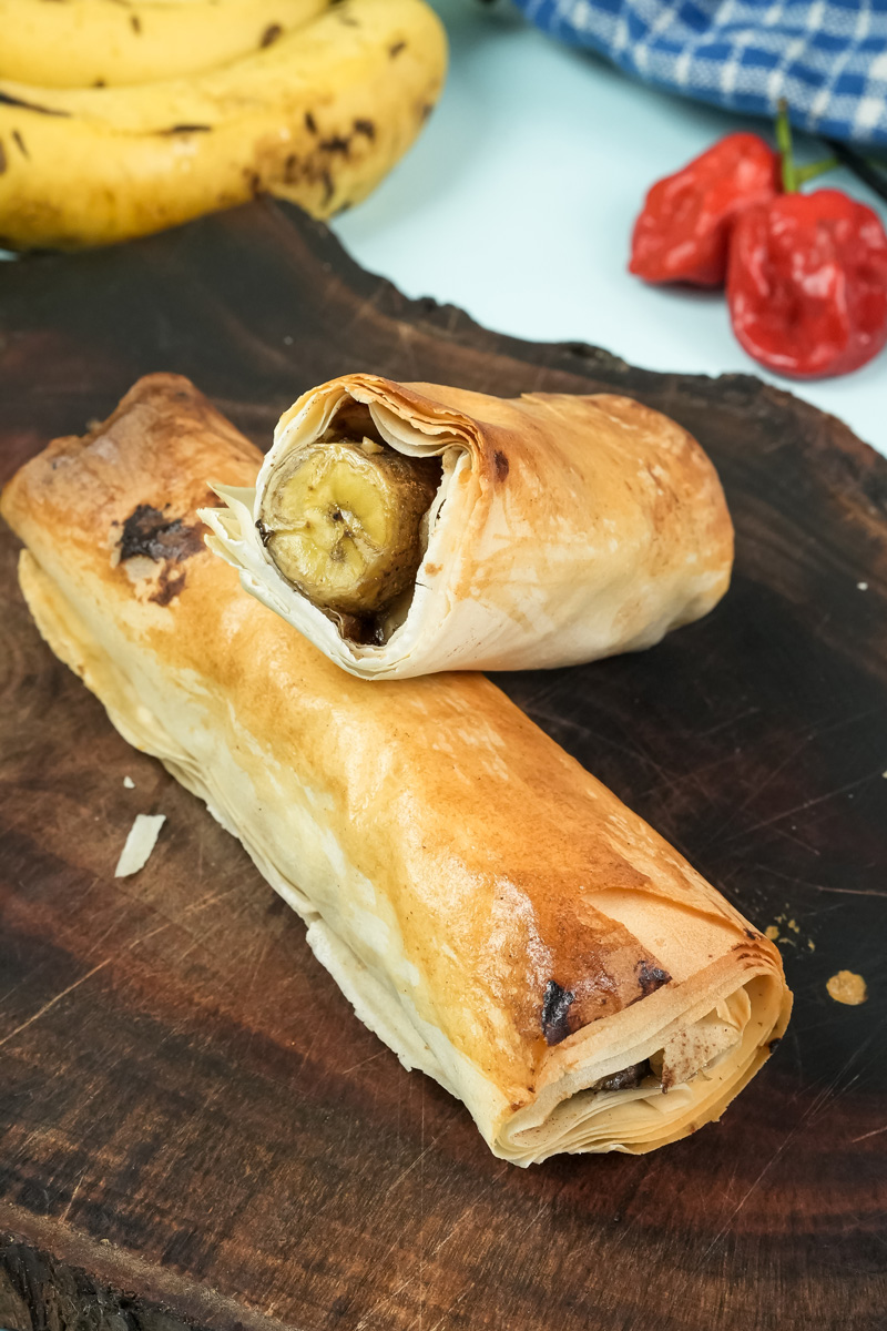 Golden baked banana strudel on wooden cutting board