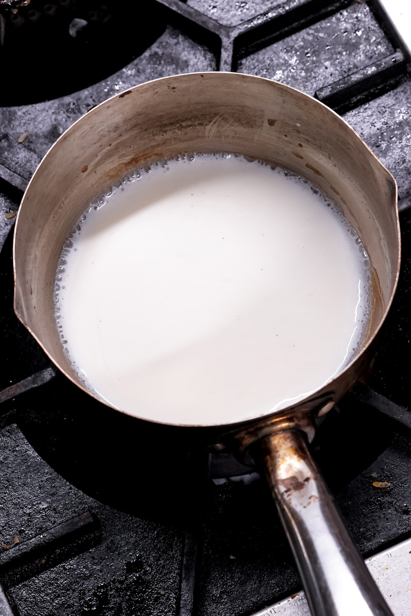 Heating milk in saucepan for mango trifle custard base