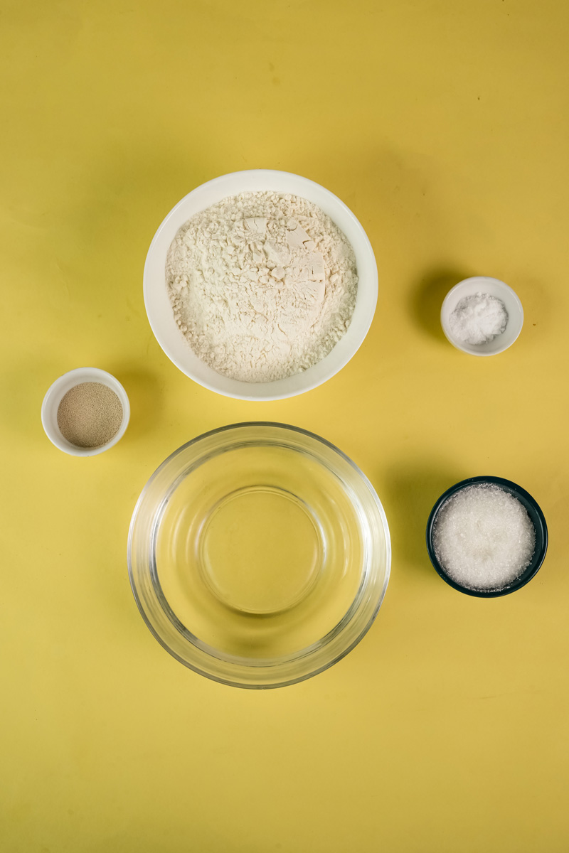 Ingredients for English Muffin Bread including flour, water, yeast, and salt in separate bowls.