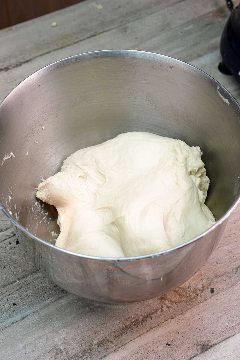 Kneaded bread bowl dough resting in a stainless steel mixing bowl before rising.