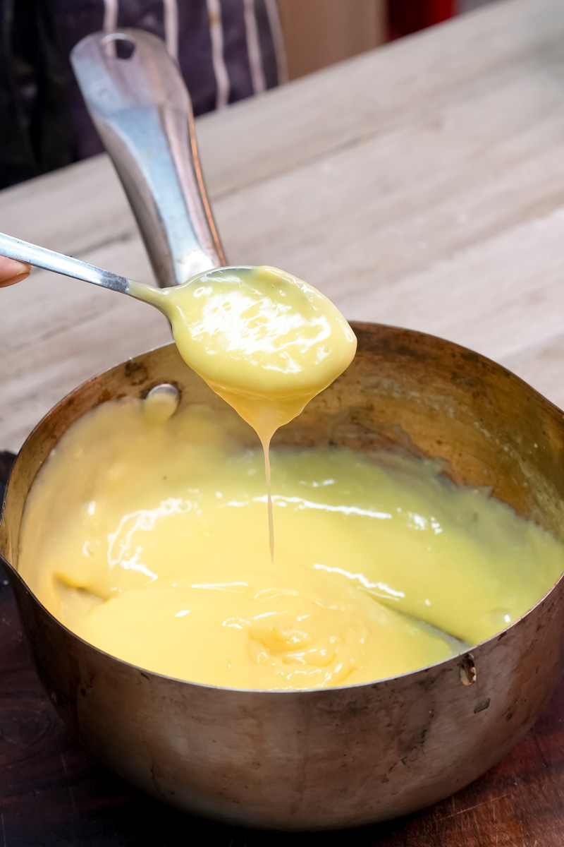 Ladle showing thick custard consistency for trifle layering