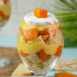 Close-up of layered mango trifle dessert in wine glass
