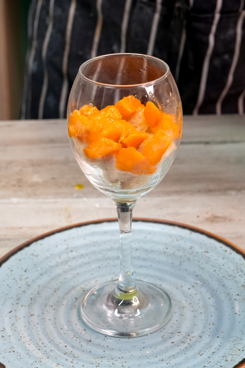Wine glass filled with bright orange mango chunks