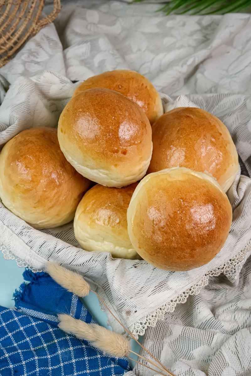 A basket filled with freshly baked, round bread bowls.