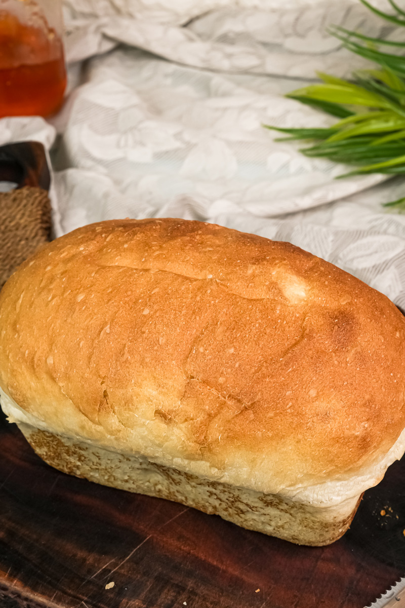 A close-up of a perfectly baked, golden-brown loaf of English Muffin Bread.