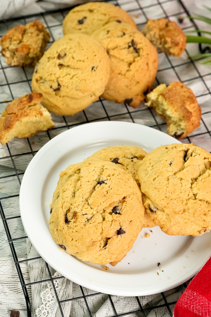 A plate of cookies surrounded by more cookies on a wire cooling rack