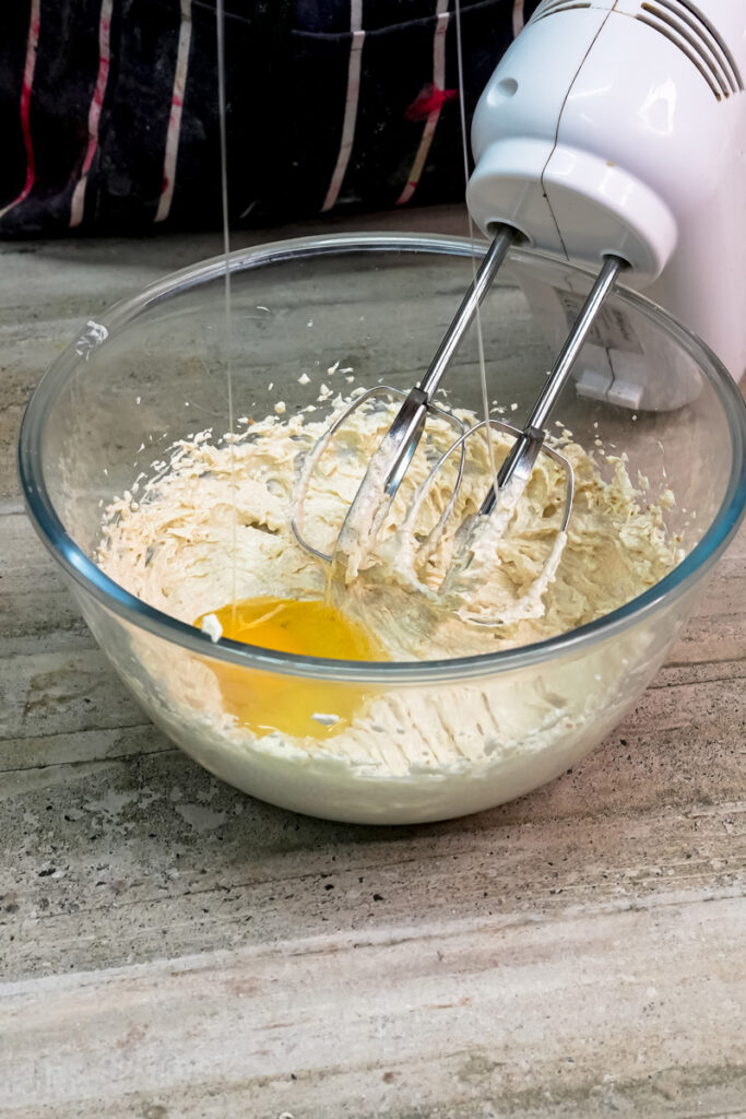 Adding an egg to the creamed butter and sugar mixture