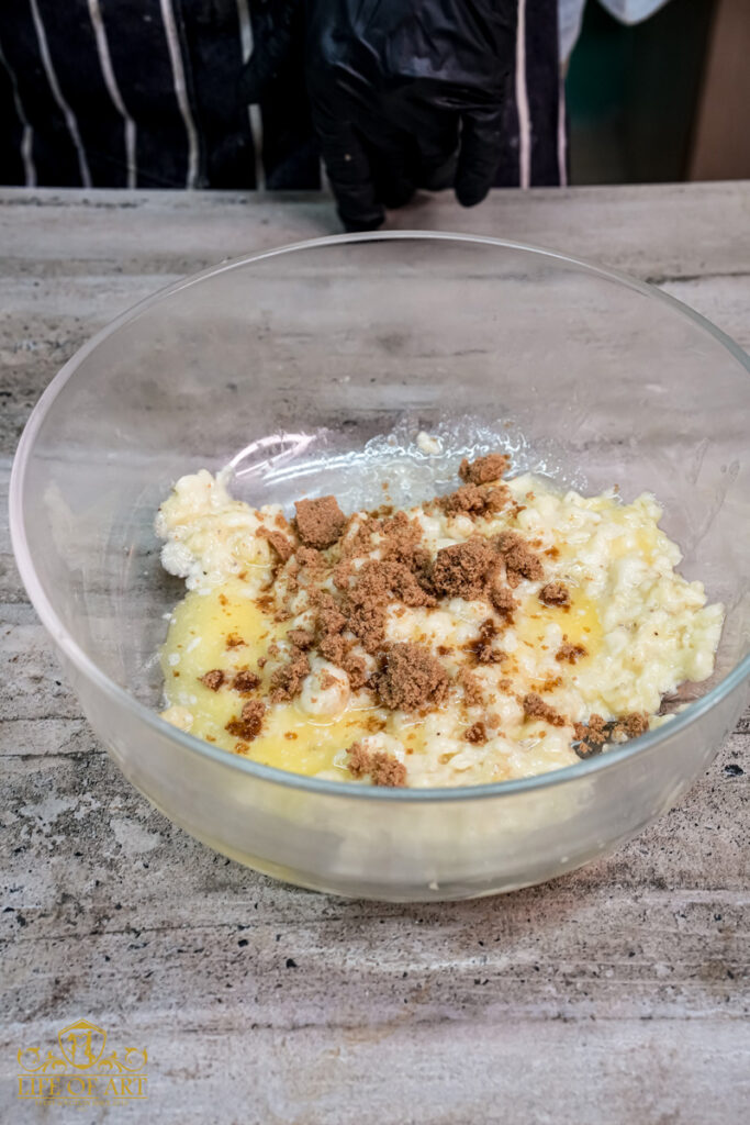 Adding brown sugar to the mashed bananas and melted butter"