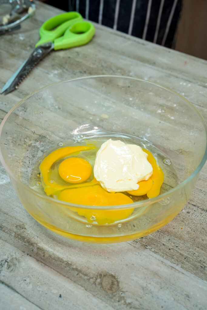 Adding butter to beaten eggs for pan de muerto dough