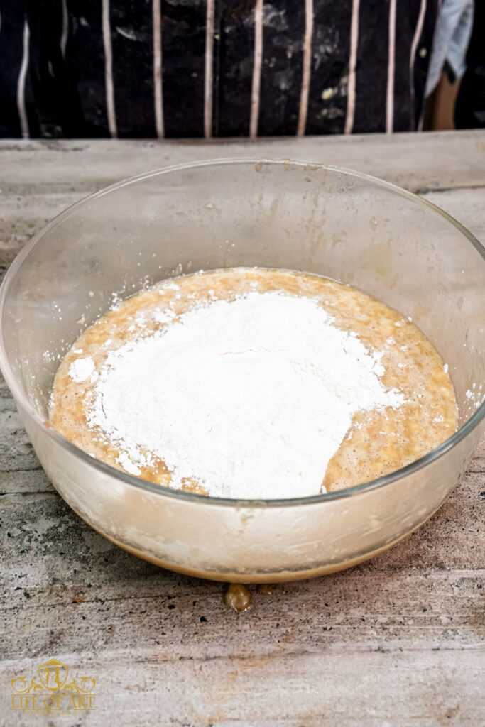 Adding flour to the wet ingredients for banana muffins